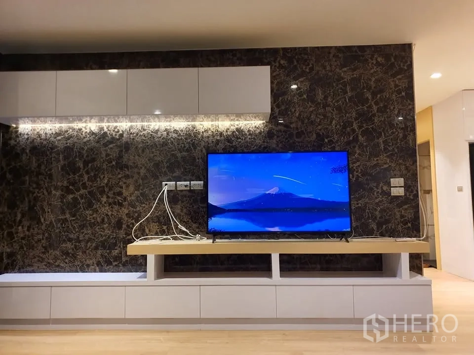 Condominium for rent in Watthana, Bangkok - Media wall with illuminated cabinets, marble feature panel and flat-screen TV.