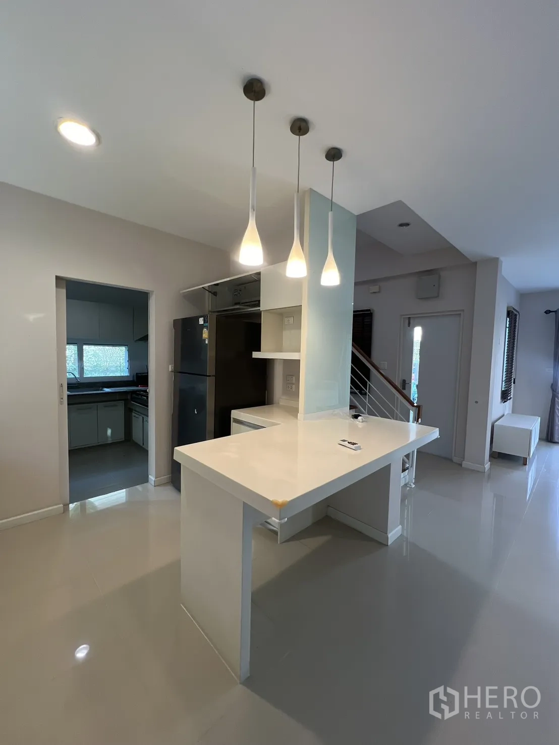 Detached House for rent in Bang Kapi, Bangkok - Bright kitchen island with pendant lights next to the stairs and entry.