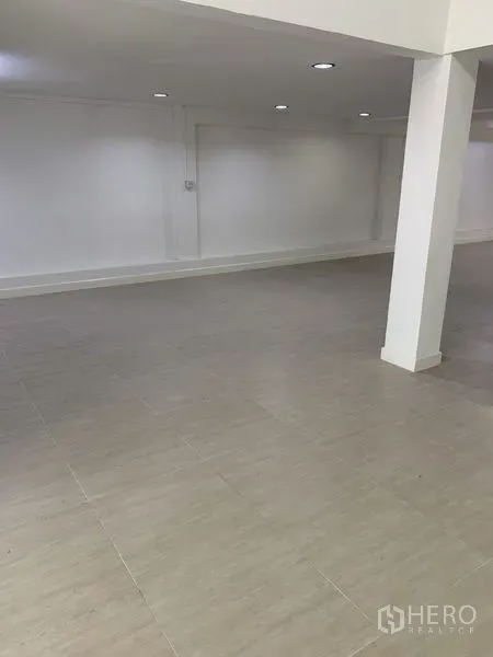 Shophouse for rent in Bang Na, Bangkok - Spacious open floor with a support column and smooth tile surface, ready for fit-out.