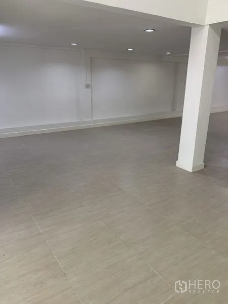 Shophouse for rent in Bang Na, Bangkok - Spacious open floor with a support column and smooth tile surface, ready for fit-out.