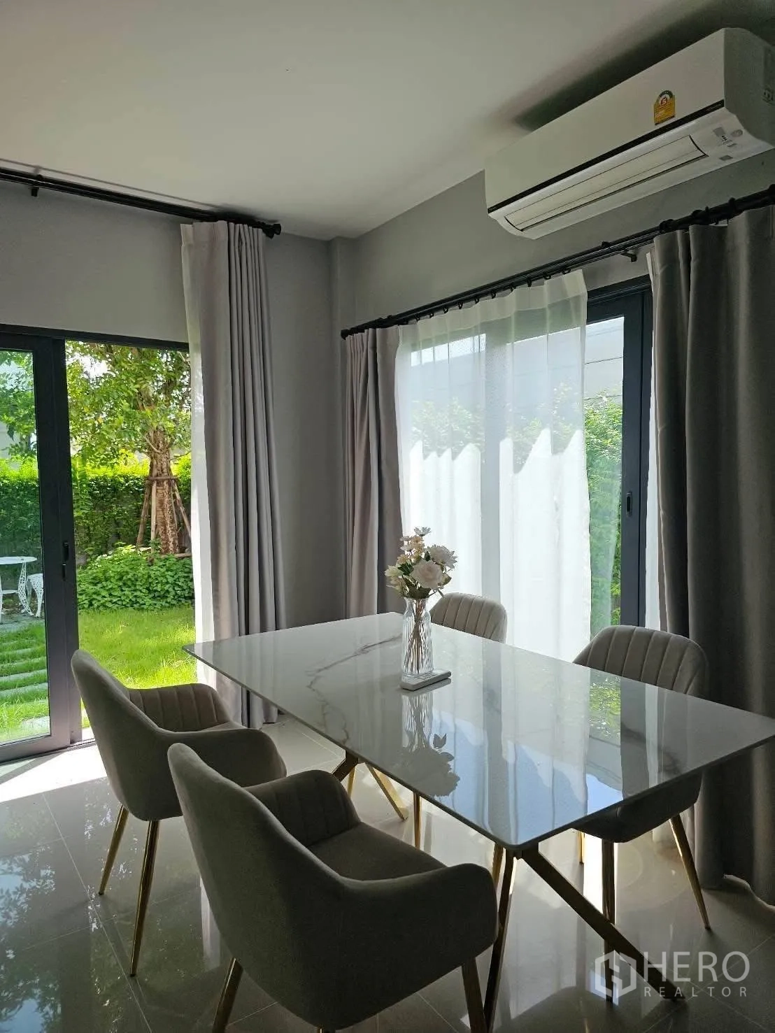 บ้าน for rent in Bang Phli, Samut Prakan - มุมทานอาหารโต๊ะหินอ่อน เก้าอี้บุนวม ข้างประตูกระจกบานเลื่อนติดสวน