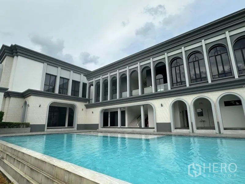 独立式住宅 出售在Khlong Sam Wa, Bangkok - 社区会所拱廊立面与室外泳池