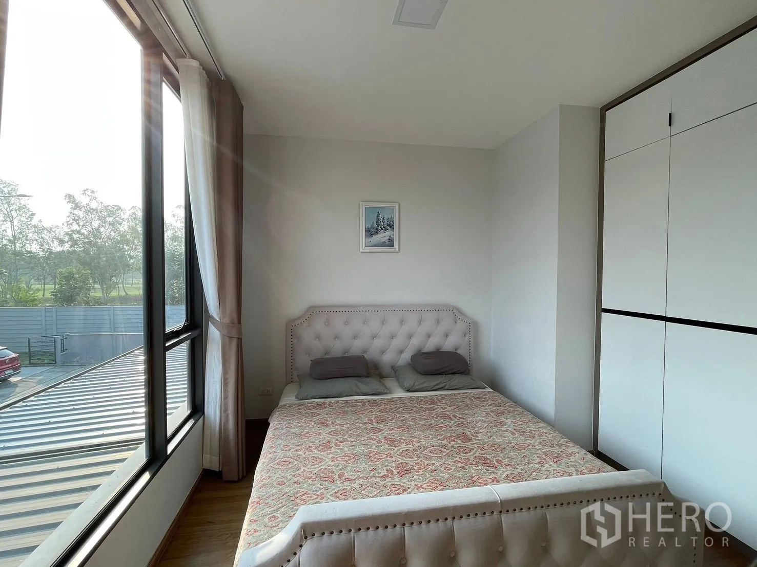 ทาวน์เฮาส์ for rent in Bang Phli, Samut Prakan - ห้องนอนมุมกระจกบานใหญ่ มองเห็นวิวต้นไม้ พร้อมเตียงบุผ้าและตู้เสื้อผ้า