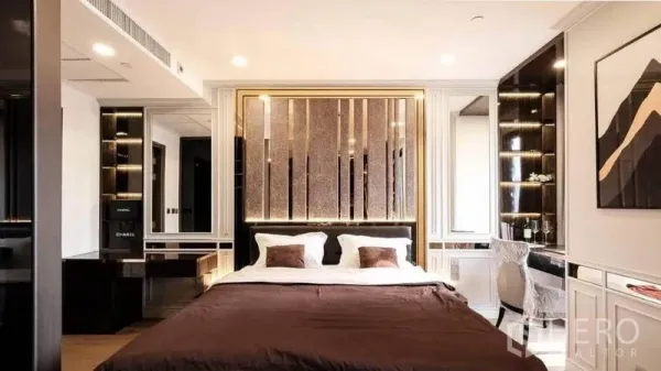 公寓 出租在Bang Rak, Bangkok - 优雅卧室，金色边框床头、内置隔板与梳妆台。
