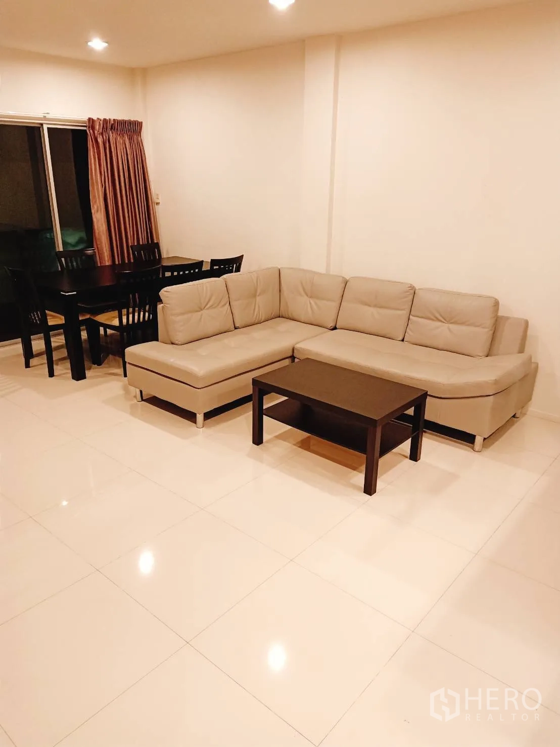 Townhouse for rent in Suan Luang, Bangkok - Open-plan living and dining room with L-shaped sofa, coffee table and sliding glass door
