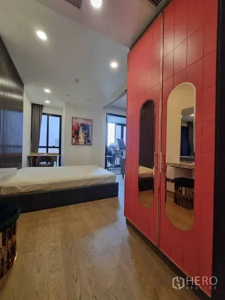 Condominium for rent in Bang Rak, Bangkok - Bedroom with red wardrobe, wood floors and large windows.