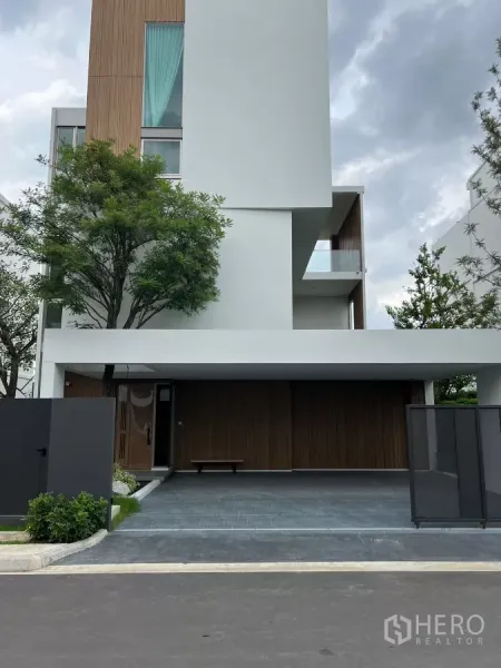 独立式住宅 出租在Saphan Sung, Bangkok - 现代多层独立屋立面，木质点缀与双车位有顶车库。