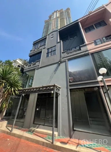 Shophouse for rent in Watthana, Bangkok - Modern multi‑storey shophouse facade on Sukhumvit with large glass frontage and nearby high‑rise in the background.