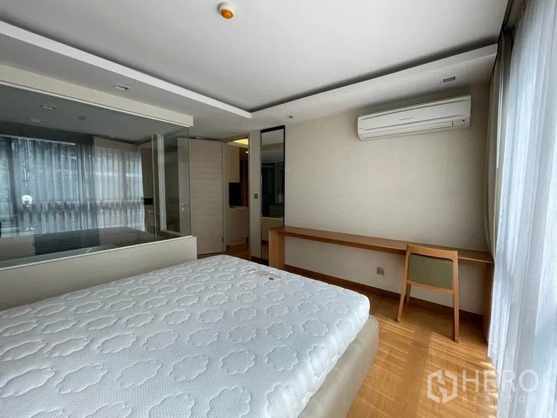 公寓 出售在Watthana, Bangkok - 明亮卧室，带书桌、大窗与通向浴室的玻璃墙。