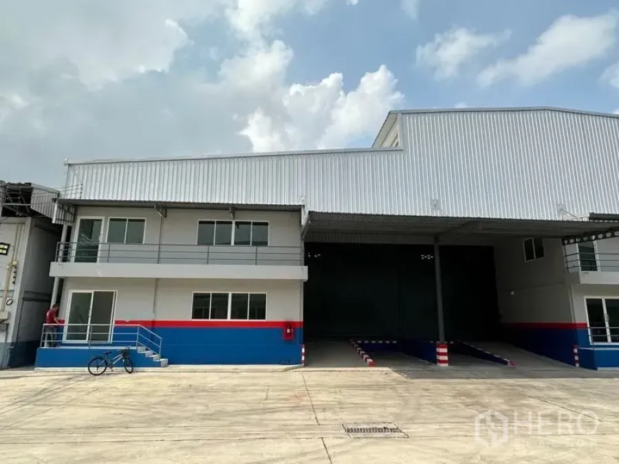 货栈 出租在Samut Prakan - 仓库外观，带两层办公区、带顶装卸坡道和宽阔车道的现代厂房