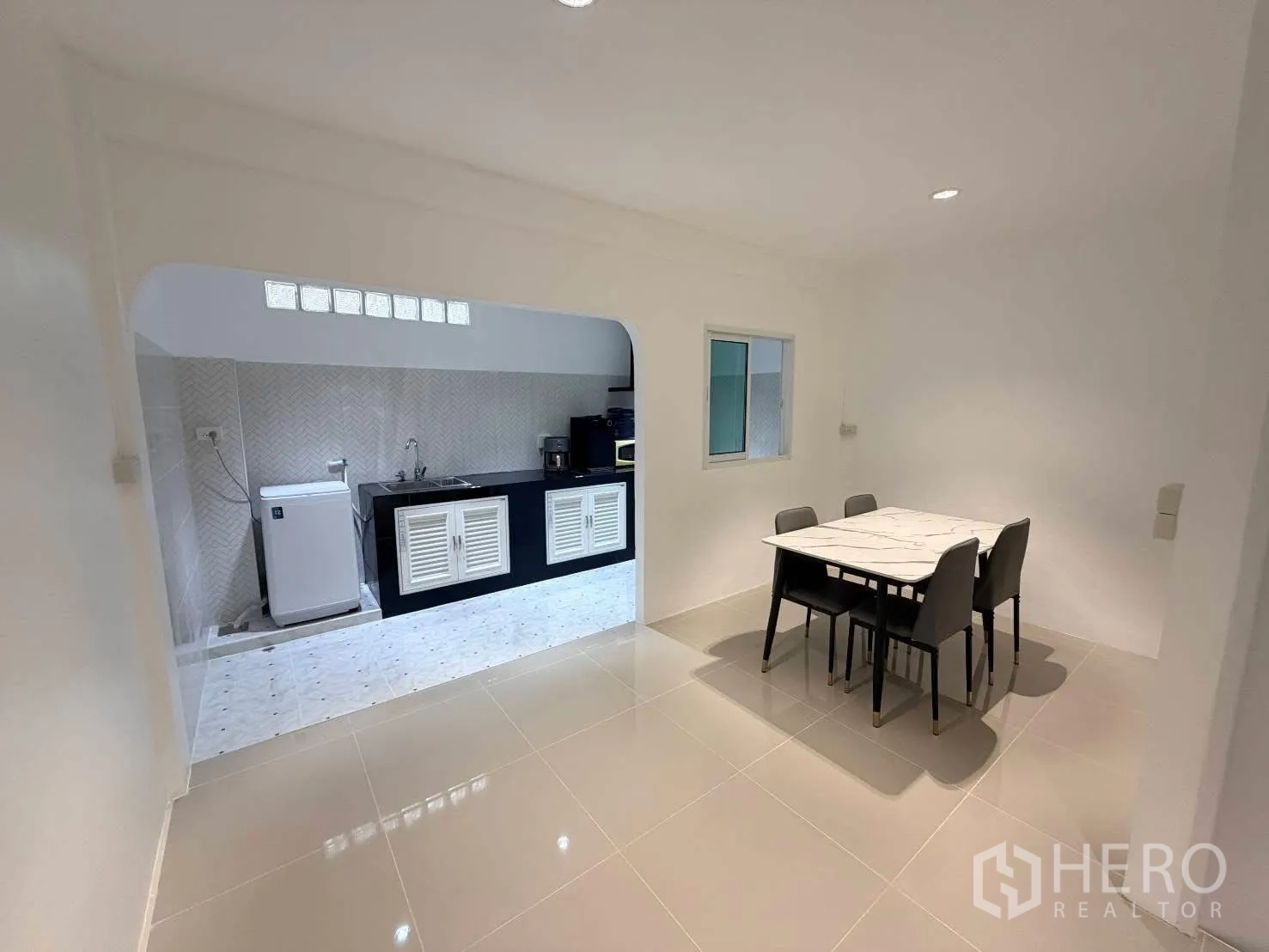 ทาวน์เฮาส์ for rent in Phra Khanong, Bangkok - พื้นที่รับประทานอาหารติดครัว มีโต๊ะสี่ที่นั่งและพื้นกระเบื้องเงา.