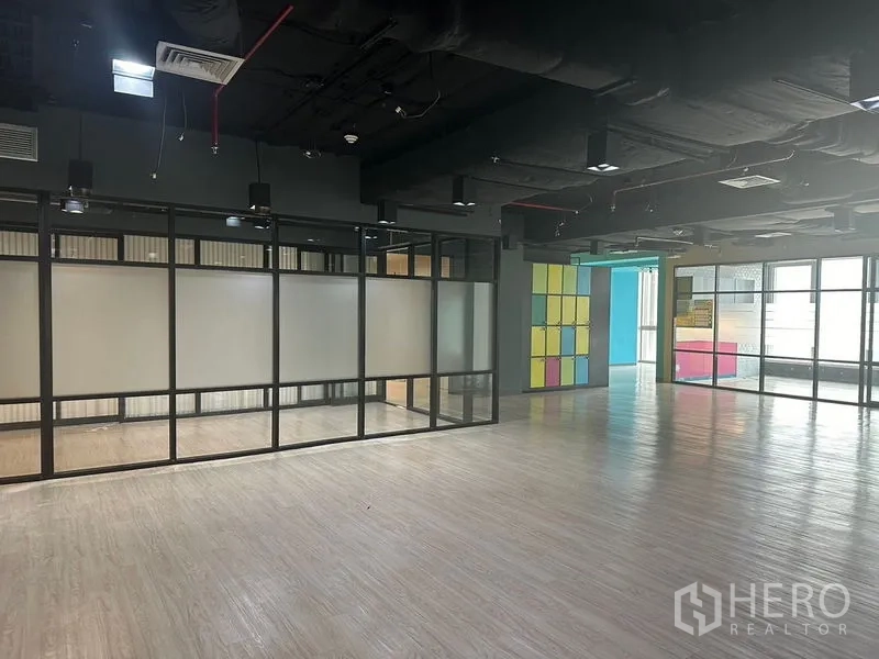 Office Space for rent in Bang Rak, Bangkok - Open-plan office with glass-walled rooms and colorful lockers in a modern workspace.