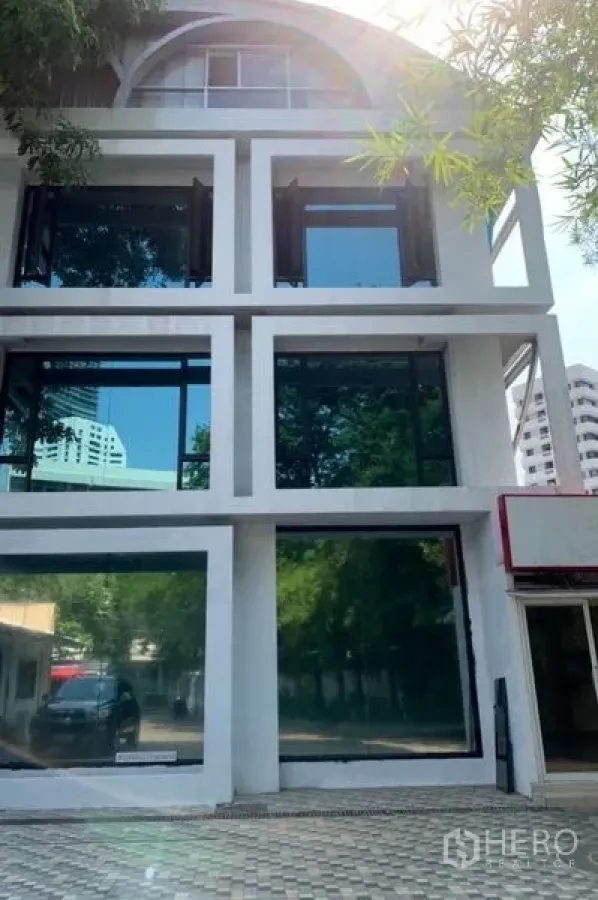 Standalone for rent in Khlong Toei, Bangkok - Facade of multi-storey standalone building with grid design and tinted windows near BTS Phrom Phong.