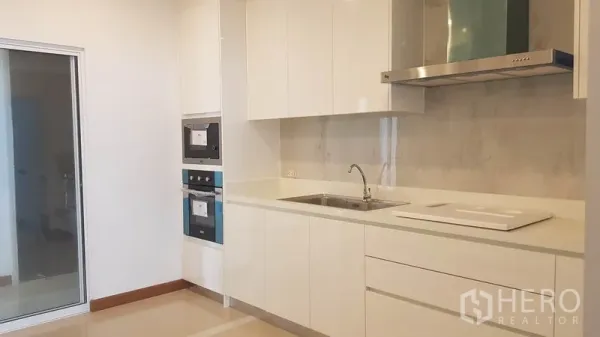 公寓 出租或出售在Yan Nawa, Bangkok - 明亮现代厨房，白色橱柜，嵌入式烤箱与排油烟机。