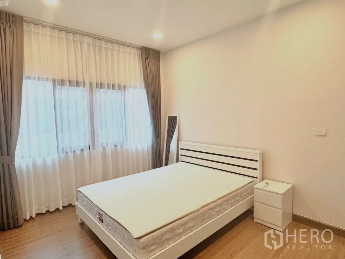 独立式住宅 出租在Bang Phli, Samut Prakan - 客房带大窗，白色床架与床头柜。