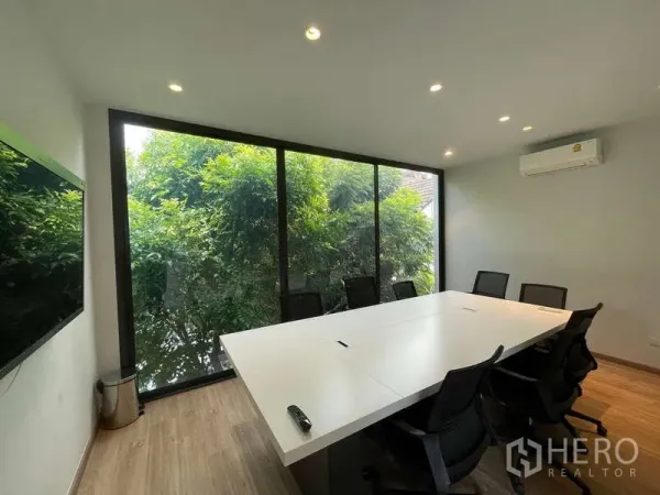 Home Office for rent in Don Mueang, Bangkok - Glass-walled meeting room with conference table, office chairs and leafy views outside.