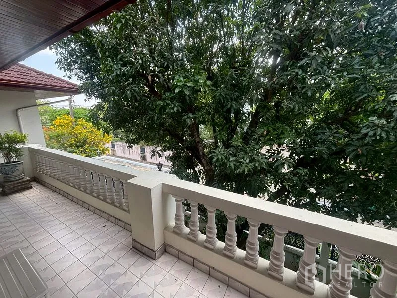 บ้านเดี่ยว for sale in Suan Luang, Bangkok - ระเบียงกระเบื้องพร้อมราวลูกกรงสีขาว มองเห็นต้นไม้ใหญ่