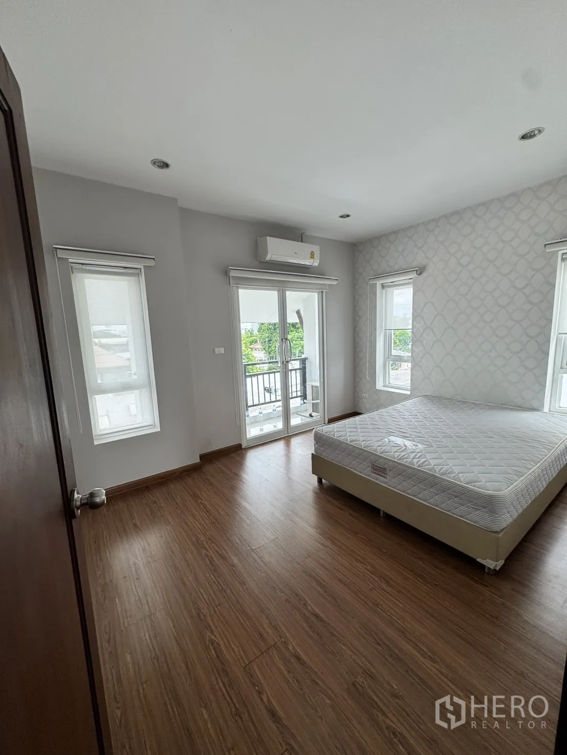 โฮมออฟฟิศ for rent in Watthana, Bangkok - ห้องนอนพื้นลายไม้ ประตูออกระเบียง และเครื่องปรับอากาศ