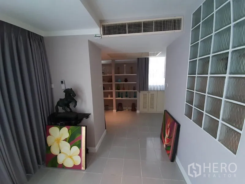 公寓 出租或出售在Watthana, Bangkok - 过道带玻璃砖墙、灰色窗帘和内置置物架。