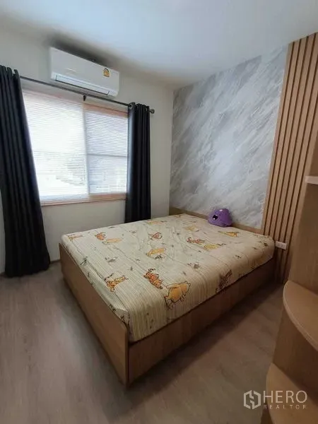 联排别墅 出租在Prawet, Bangkok - 卧室设木质装饰墙、内置书架并配空调。