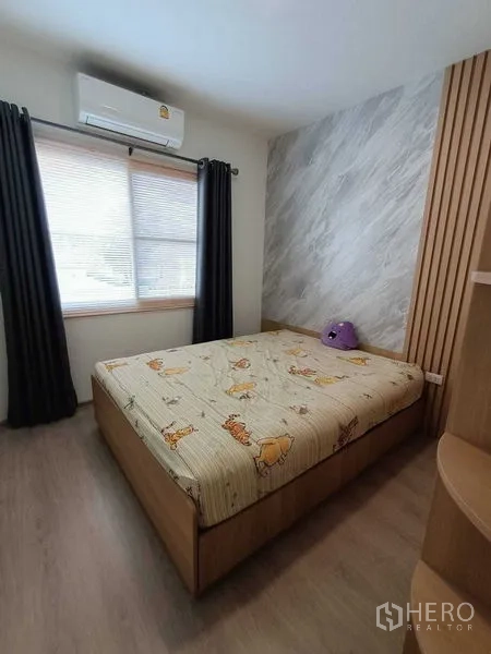 联排别墅 出租在Prawet, Bangkok - 卧室设木质装饰墙、内置书架并配空调。