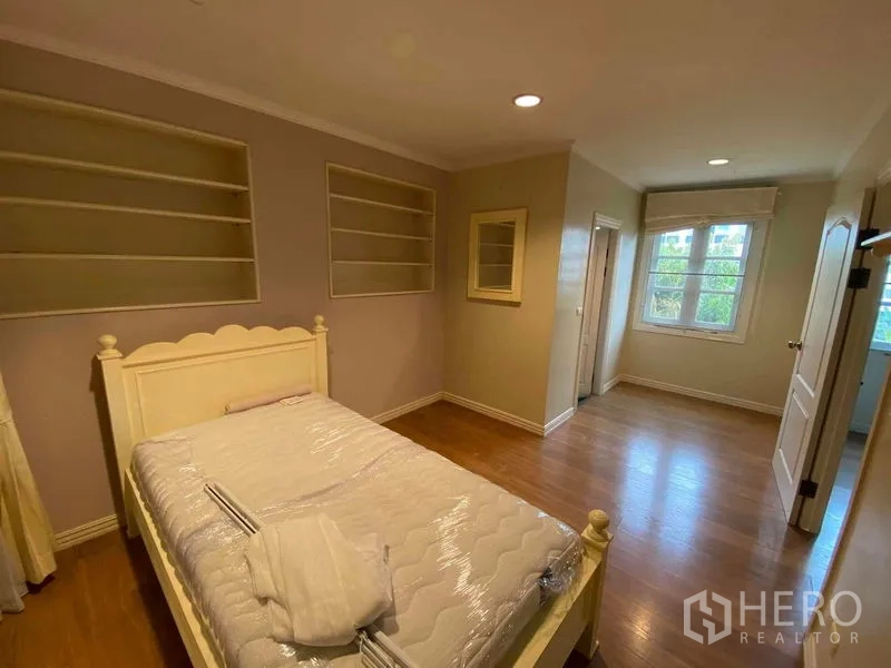 Townhouse for rent or sale in Mueang Samut Prakan, Samut Prakan - Bedroom with built-in wall shelves, single bed and timber flooring.