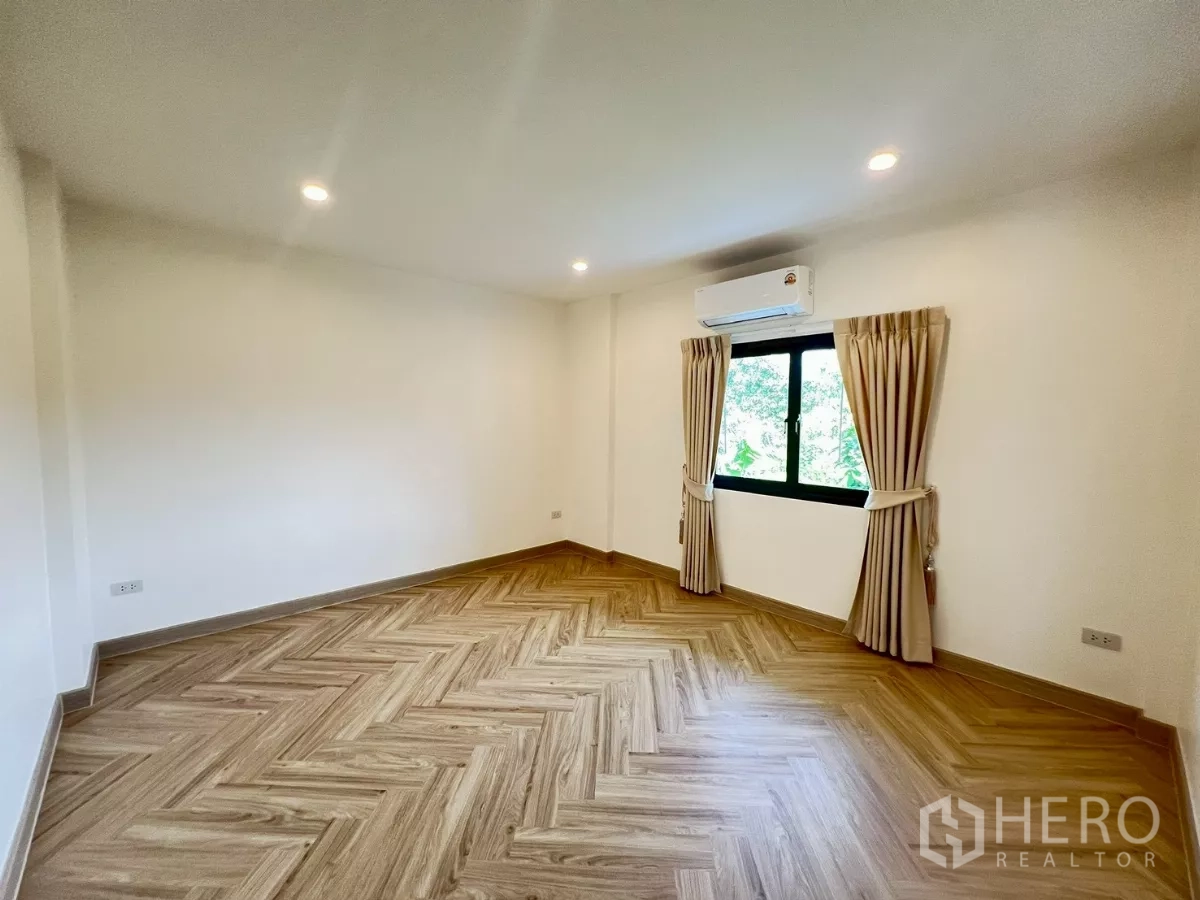 独立式住宅 出租在Suan Luang, Bangkok - 第三卧室未配置家具，人字形地板与花园景观。