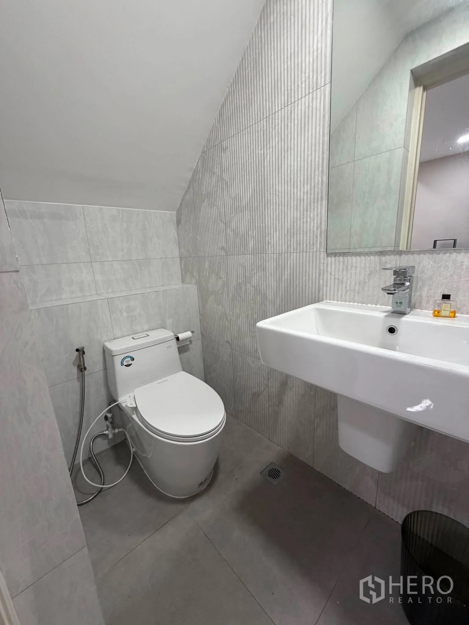 家庭办公室 for rent in Phra Khanong, Bangkok - 瓷砖卫生间，配坐便器、洗手盆和喷枪。