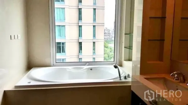 公寓 出租在Pathum Wan, Bangkok - 带大观景浴缸的浴室，窗外可见邻近楼栋。