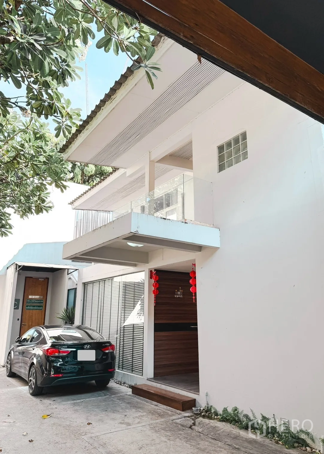 家庭办公室 for rent in Watthana, Bangkok - 白色外立面带阳台的办公住宅，门前车道与停车位，绿树成荫。