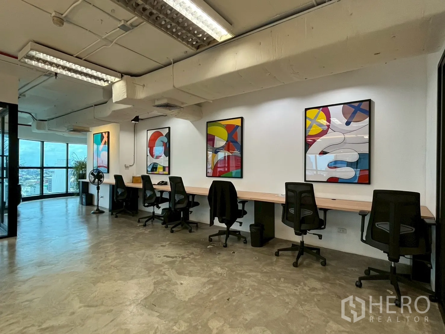 ออฟฟิศ for rent in Watthana, Bangkok - แถวโต๊ะทำงานพร้อมเก้าอี้สำนักงาน งานศิลป์บนผนัง และพื้นคอนกรีตขัดเงา