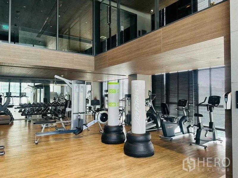 Condominium for rent in Khlong Toei, Bangkok - Fully equipped fitness center with cardio machines, weights, and boxing bags.