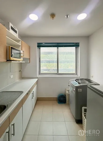 公寓 出租在Huai Khwang, Bangkok - 独立带窗厨房，配橱柜、水槽、冰箱、微波炉和洗衣机。