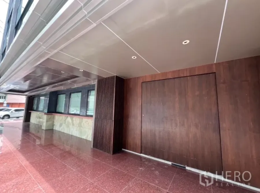 Retail Space for rent in Khlong Toei, Bangkok - Covered street frontage with wood facade and large door on a red stone terrace.