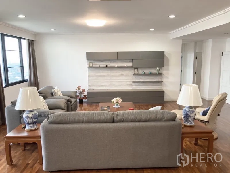 Condominium for rent in Yan Nawa, Bangkok - Living area with built-in media wall, modern lighting and picture window.