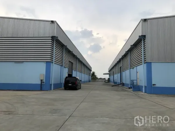 货栈 出租在Samut Prakan - 成排仓库与宽阔混凝土场地，卡车出入与停车便捷。