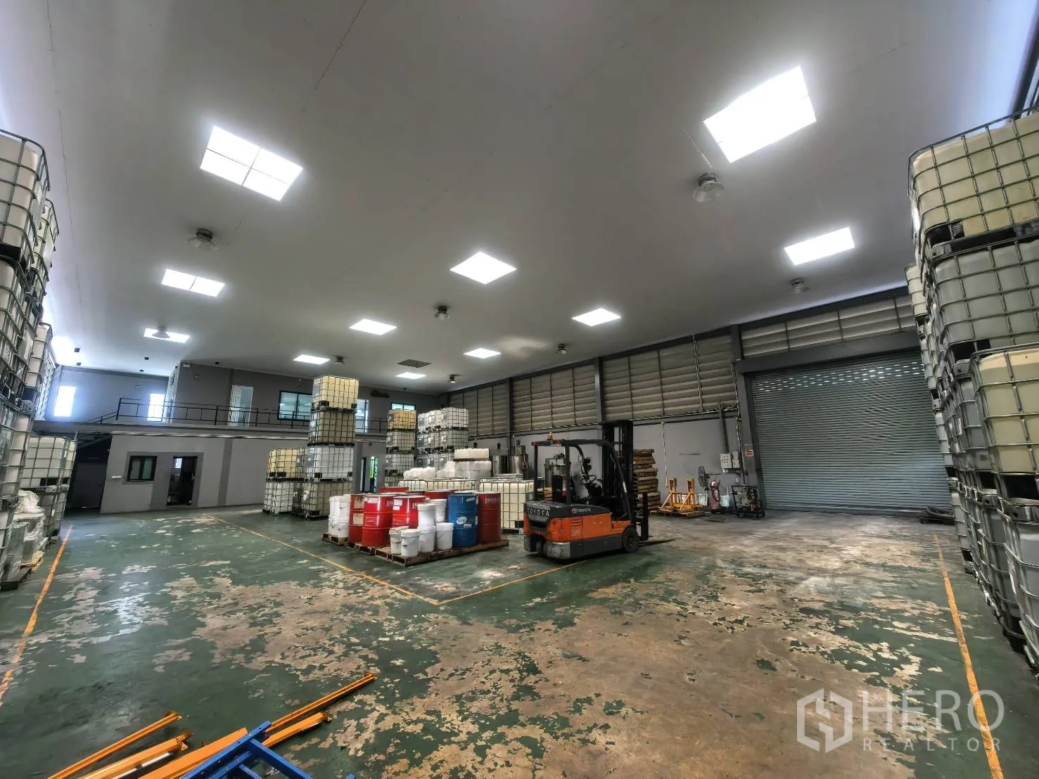 仓库 for rent in Bang Sao Thong, Samut Prakan - 仓库地面有叉车、卷帘门与储物容器。