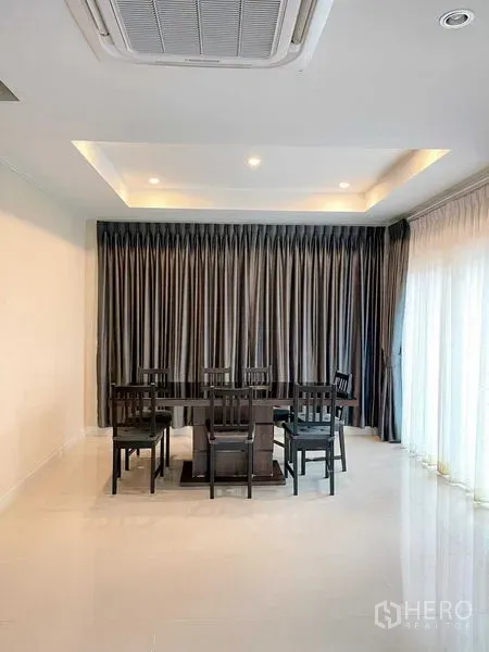 บ้าน ขายในBang Phli, Samut Prakan - พื้นที่รับประทานอาหารกว้าง โต๊ะหกที่นั่ง ฝ้าหลุมซ่อนไฟ และผ้าม่านสูงจรดพื้นริมประตูกระจก
