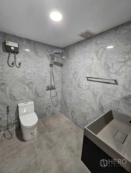 Condominium for rent or sale - Bathroom with gray marble tiles and a walk-in shower.