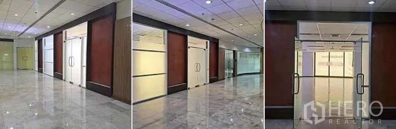 Office Space for rent in Phaya Thai, Bangkok - Glass double-door entrance along a marble corridor with wood wall panels leading into the office unit.