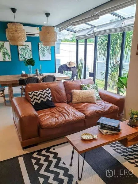 บ้าน ขายในBang Phli, Samut Prakan - พื้นที่นั่งเล่นโซฟาหนังสีน้ำตาล ผนังกระจกมองสวน