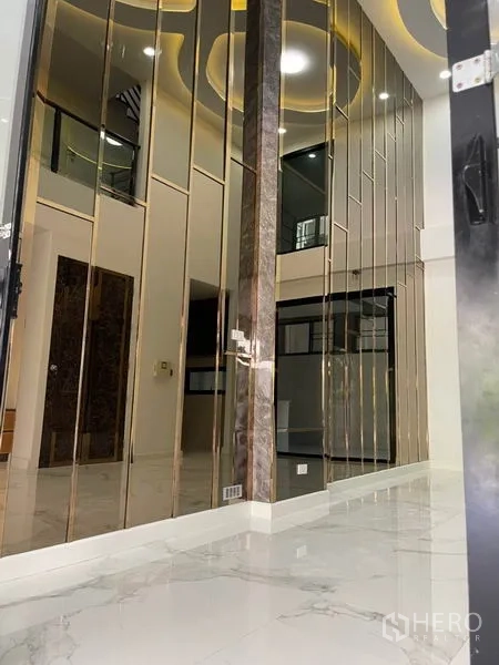 Townhouse for rent or sale in Yan Nawa, Bangkok - Vertical bronze mirror panels forming a decorative hallway feature wall.