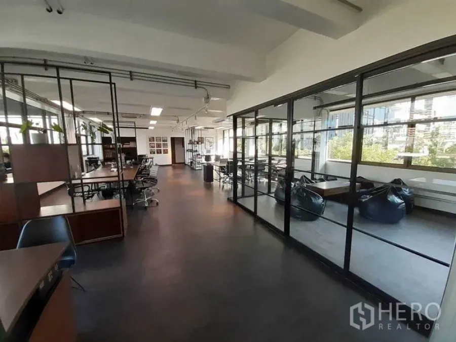 办公空间 出租在Khlong Toei, Bangkok - 办公室走道旁设玻璃会议室与懒人沙发休闲区，采光充足。