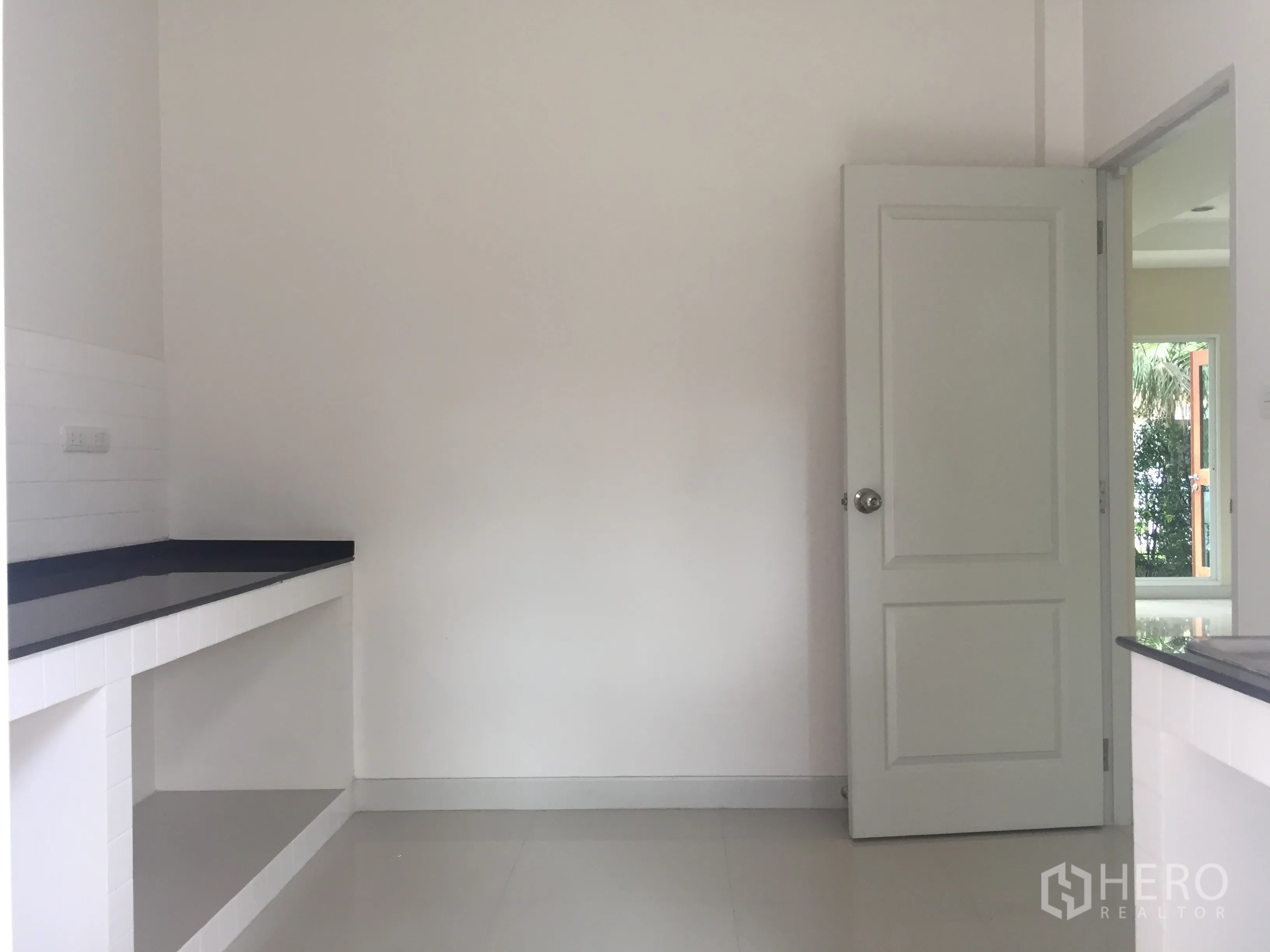 Detached House for sale in Saphan Sung, Bangkok - Minimalist white kitchen with black stone countertops and open shelves.