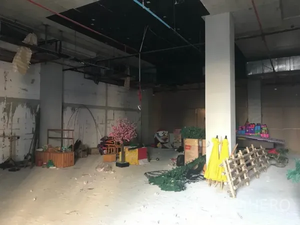 Retail Space for rent in Khlong Toei, Bangkok - Open-plan retail unit with a central column, rough walls and ceiling grid, and stored fixtures.