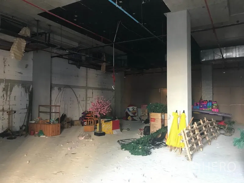 Retail Space for rent in Khlong Toei, Bangkok - Open-plan retail unit with a central column, rough walls and ceiling grid, and stored fixtures.
