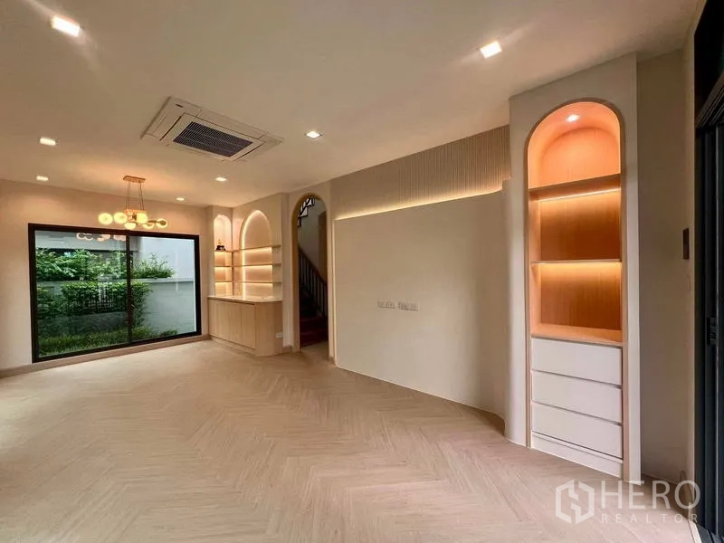 Detached House for sale in Bang Kruai, Nonthaburi - Open-plan lounge featuring arched illuminated shelving, recessed lighting and access to the staircase.
