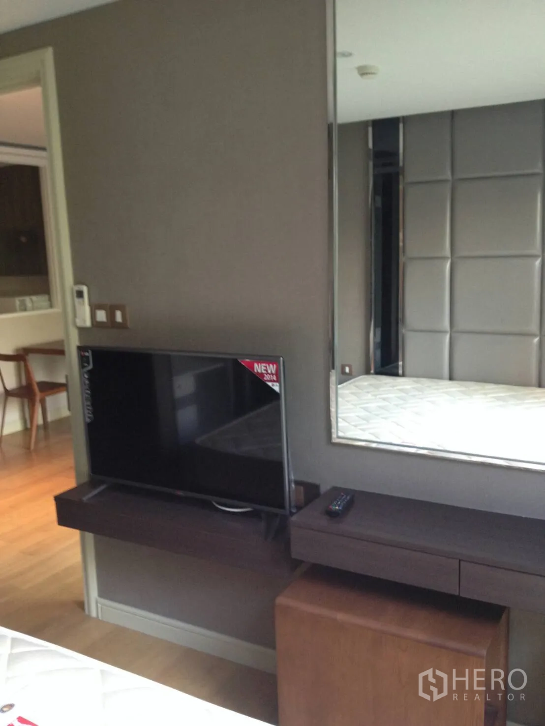 Condominium for rent in Khlong Toei, Bangkok - Bedroom media wall with flat-screen TV, mirror and small work desk.