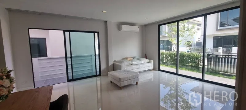 Detached House for rent in Saphan Sung, Bangkok - Corner living area with two walls of sliding glass overlooking the garden.