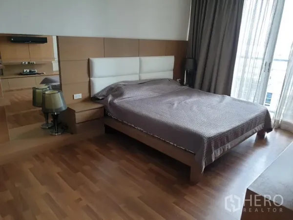 公寓 出租在Watthana, Bangkok - 宽敞主卧，双人床、床头柜、木地板，纱帘通向阳台。